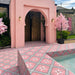 Outdoor swimming pool area featuring Galata Pink 20cm x 20cm Moroccan style tiles across the pool surround and sides, showcasing a bold pink geometric star pattern against a coordinating pink exterior.