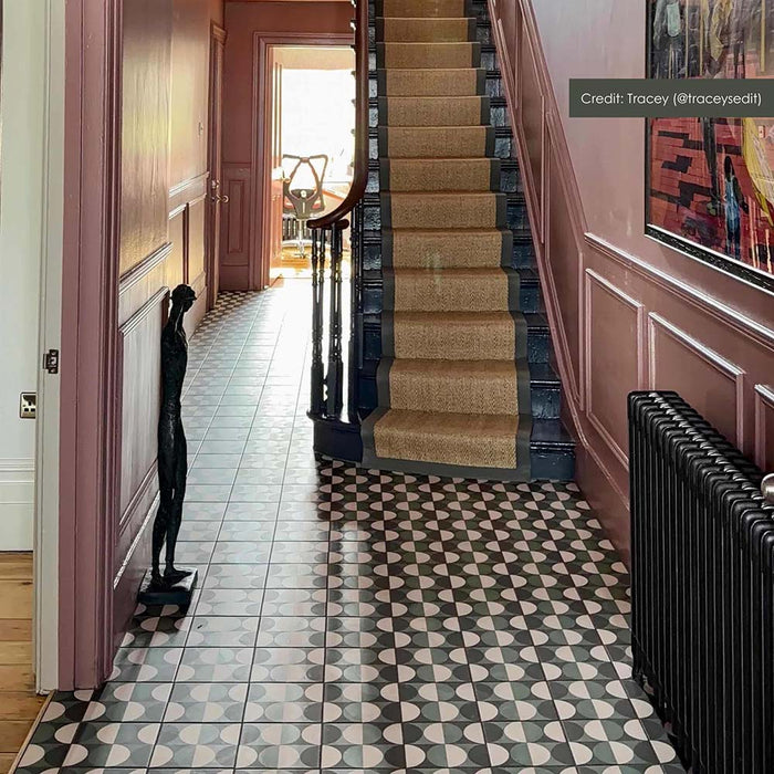 Hallway featuring Geometry Circulo patterned tiles 20 × 20cm, creating a bold geometric floor with repeating circular motifs. Paired with panelled walls and a staircase runner for a striking, characterful entrance.