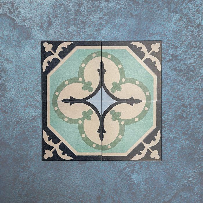 Four Europa Gothenberg 20x20cm Victorian Moroccan style tiles displayed together against a textured blue background, forming a symmetrical geometric pattern in blue, mint green and cream tones.