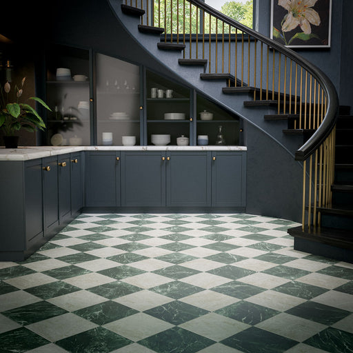 Interior featuring Grand Bazaar Mahal and Grand Bazaar Verde Green marble-effect chequerboard floor tiles, combining soft white and rich green tones in a timeless checkerboard design. Styled with dark navy cabinetry, brass detailing, marble worktops and a sweeping staircase, creating a sophisticated and elegant space that balances classic design with contemporary luxury.