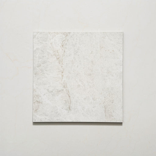 Close-up of Grand Bazaar Mahal matt marble-effect tile in a 30cm x 30cm format, featuring soft white and light grey tones with subtle natural stone-inspired movement and delicate veining. The understated marble effect creates a timeless, elegant finish, making it ideal for chequerboard floor designs, bathrooms, hallways and classic interior schemes.