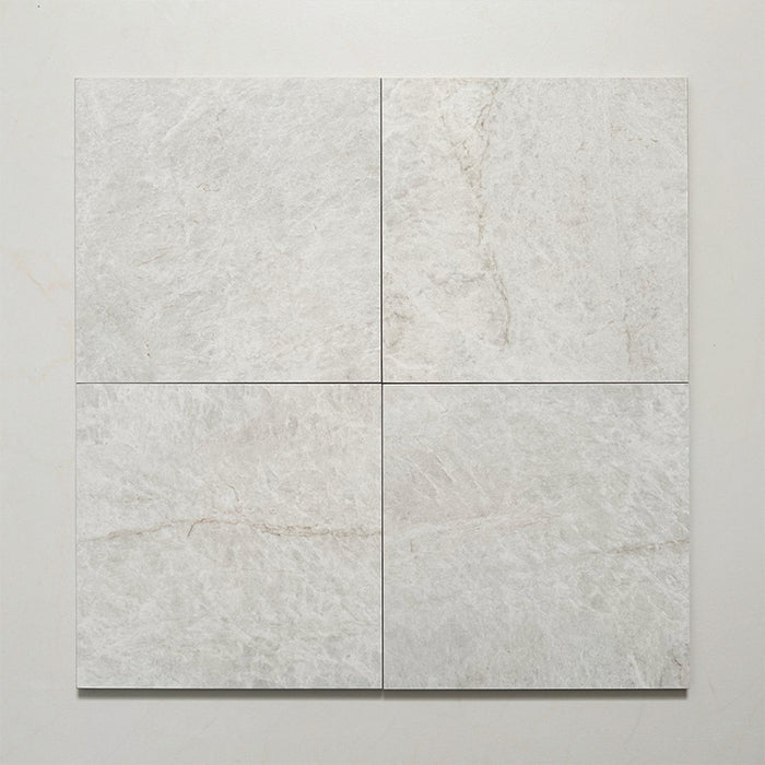 Close-up of Grand Bazaar Mahal matt marble-effect tile in a 30cm x 30cm format, featuring soft white and light grey tones with subtle natural stone-inspired movement and delicate veining. The understated marble effect creates a timeless, elegant finish, making it ideal for chequerboard floor designs, bathrooms, hallways and classic interior schemes.