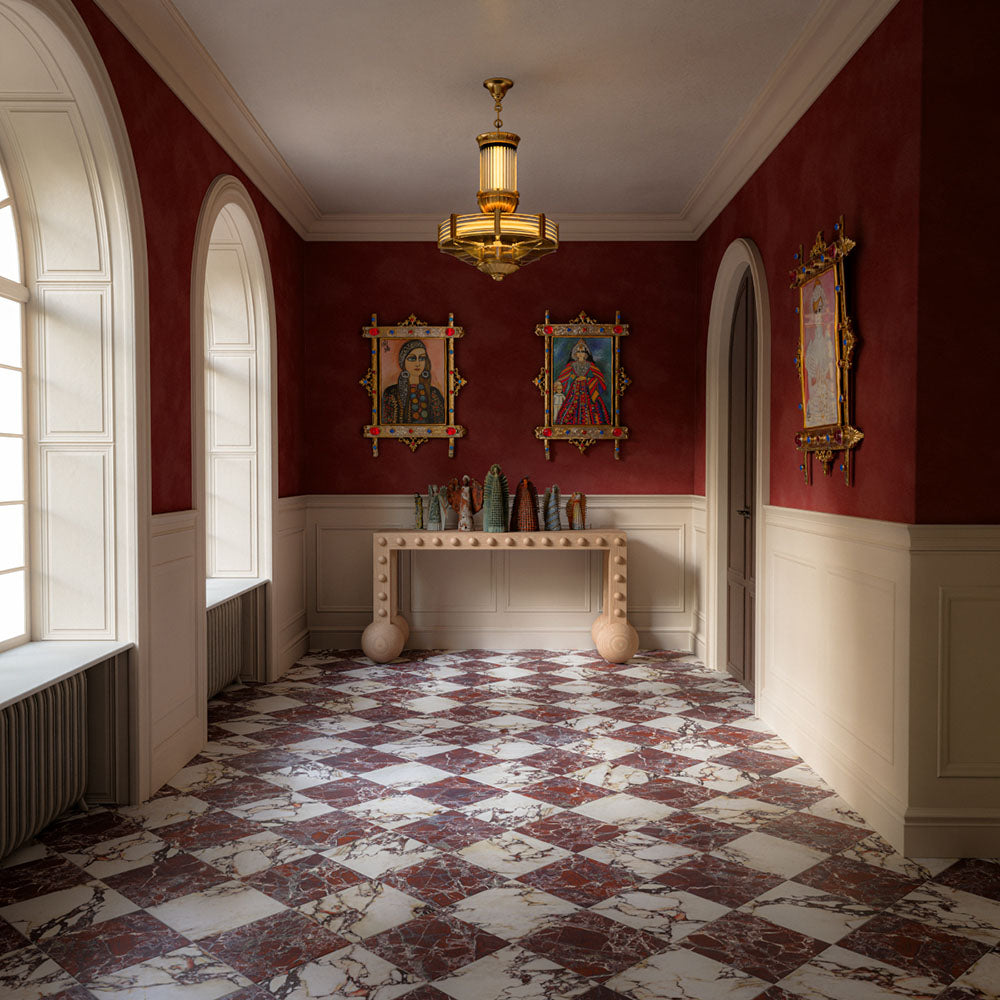 Interior featuring Grand Bazaar Violetta Matt and Grand Bazaar Levant Rouge marble-effect chequerboard floor tiles, combining rich burgundy, deep violet and white tones in a striking geometric layout. Styled with warm red walls, decorative artwork, elegant lighting and classic architectural details to create a luxurious, maximalist-inspired space full of character.