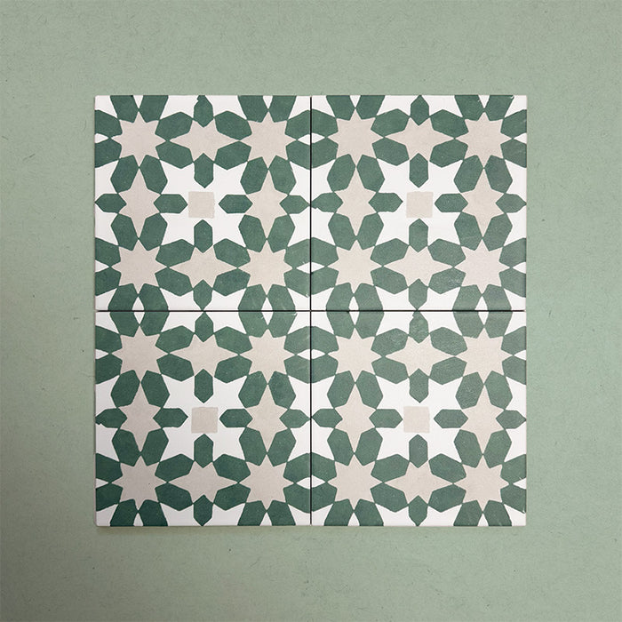 Group of Soukaina Green C Moroccan-style 20cm x 20cm patterned porcelain tiles, showing a repeating geometric star pattern in deep green and soft neutral tones with a matt finish.