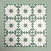 Group of Soukaina Green D Moroccan-style 20cm x 20cm patterned porcelain tiles, showing a repeating central star motif in deep green, white and soft neutral tones with a matt finish.