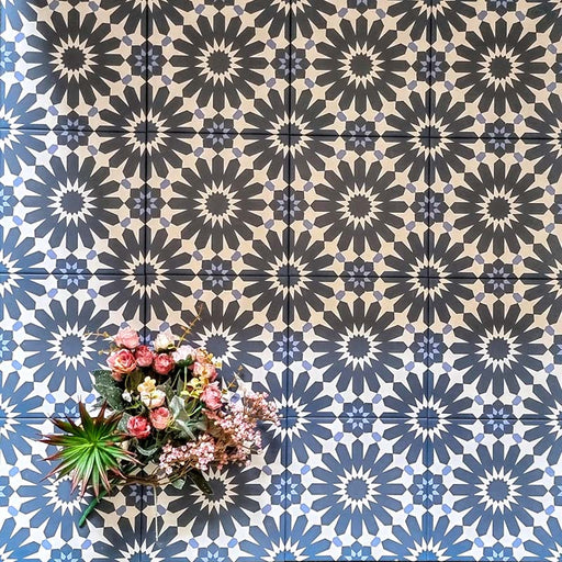 Arrangement of Fizaan Federal Blue 20x20cm Moroccan-style porcelain tiles, showcasing a repeating geometric pattern in deep blue and soft neutral tones.