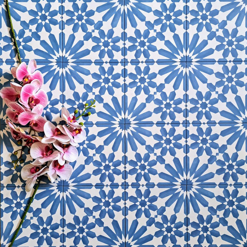 Arrangement of Fizaan Azure Blue 20x20cm Moroccan-style porcelain tiles, showcasing a repeating geometric pattern in vibrant blue and white tones.