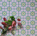 Fizaan Summer Mini Moroccan-style 15×15cm tiles laid in a repeating geometric pattern, featuring blue, green and pink floral star motifs.