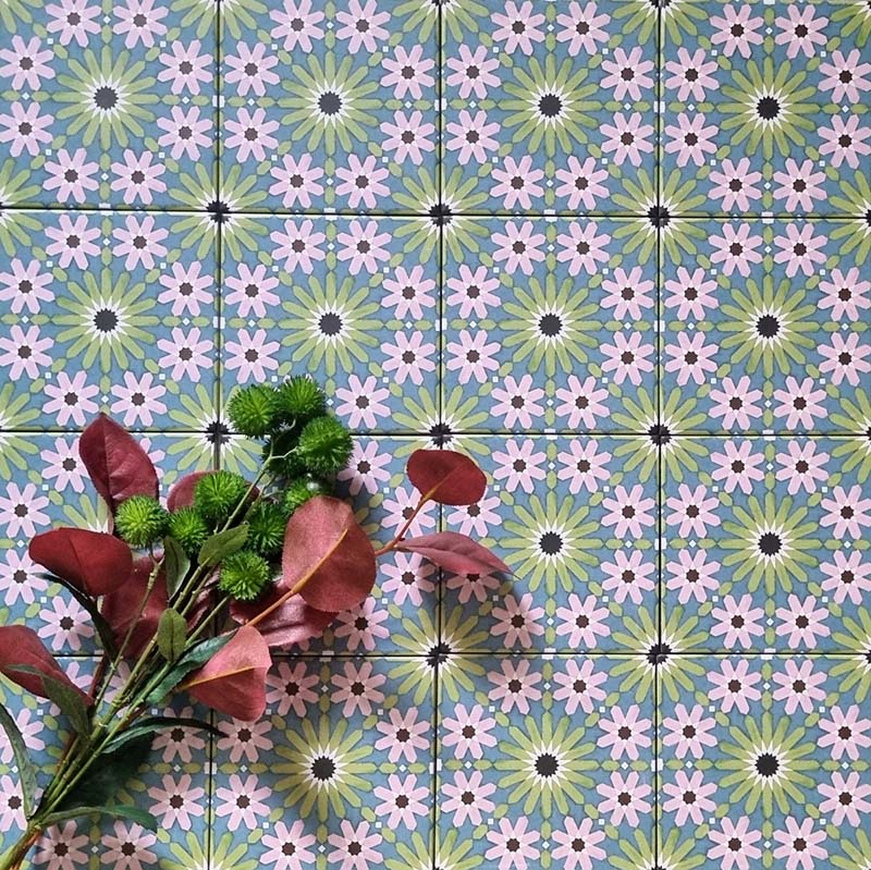 Fizaan Summer Mini Moroccan-style 15×15cm tiles laid in a repeating geometric pattern, featuring blue, green and pink floral star motifs.