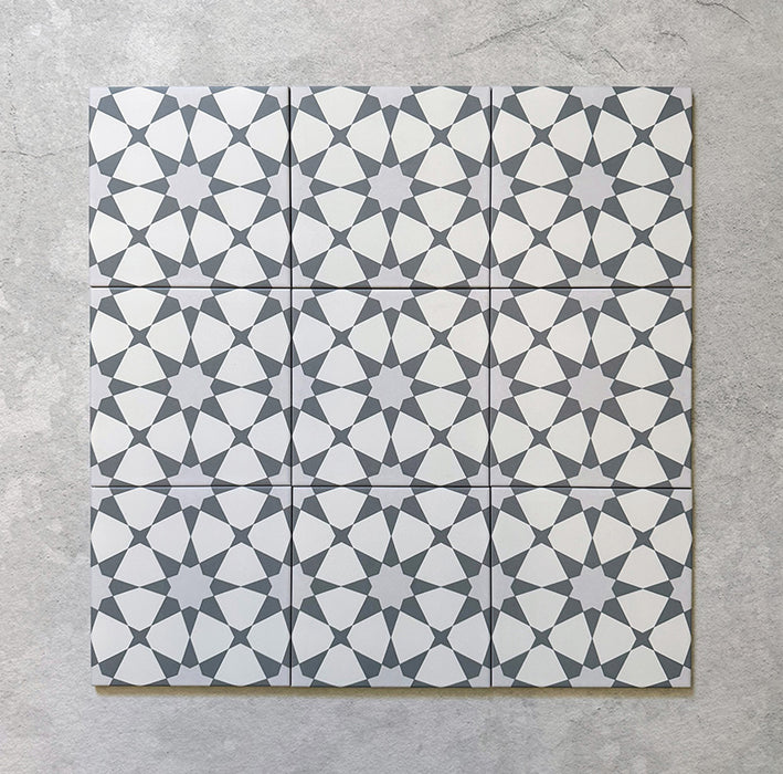 Agraba Silver 20x20cm Moroccan tiles shown in a grouped layout, featuring a repeating soft grey and white geometric star pattern that creates a timeless, elegant surface for walls or floors.