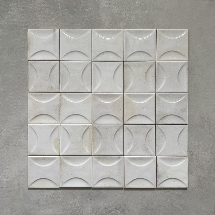 Group image of Beijing White Décor 10x10cm Moroccan square tiles arranged in a grid, featuring a raised crescent pattern and soft off-white glaze with subtle tonal variation for a handcrafted look.
