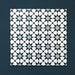 Close-up of multiple Agraba Azul Blue 20x20cm Moroccan-style ceramic tiles arranged in a grid, displaying a geometric star pattern in navy, light blue, and white on a deep blue background.