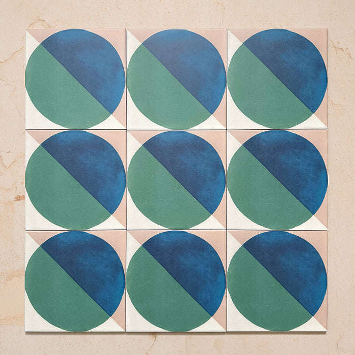 Group image showing nine Geometry Ocean 20x20cm geometric patterned tiles arranged in a grid, featuring blue and green semicircles on a sand and white background, photographed against a neutral stone surface.