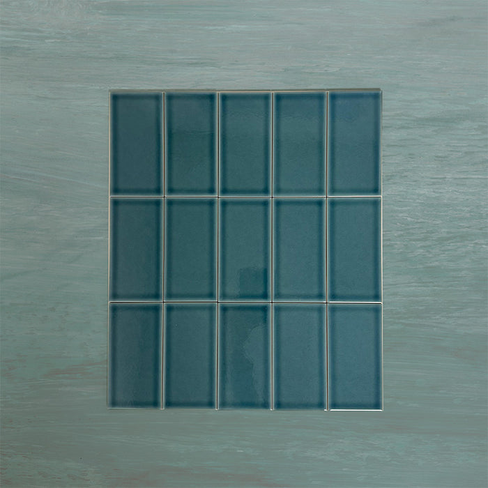 Flat lay of Finchley River Blue 7.5 × 15cm ceramic tiles with a crackle glaze finish, highlighting rich blue tones, subtle surface texture and tonal variation for elegant wall tile designs.