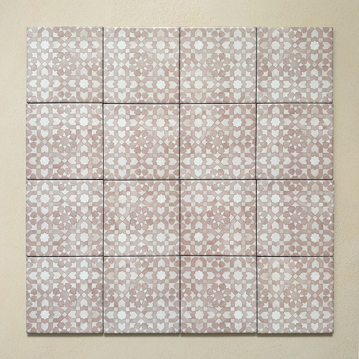 Bedouin Tetuan Rose Moroccan-style 15x15cm group of tiles arranged in a square layout. The design features a blush pink and white geometric star pattern with a handcrafted matte finish, creating a soft and decorative mosaic effect against a warm beige background.