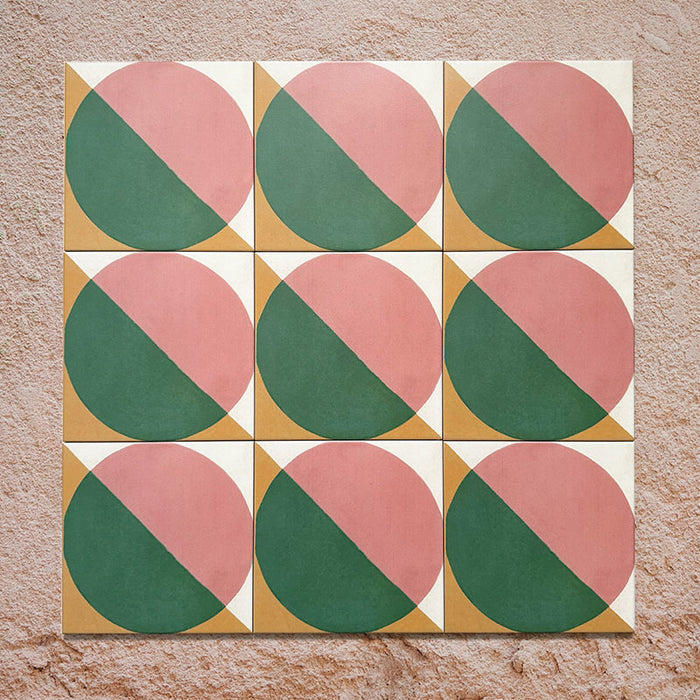 Group image showing nine Geometry Paloma 20x20cm geometric patterned tiles arranged in a grid, featuring pink and green semicircles with mustard and cream corner details, photographed against a textured stone background.