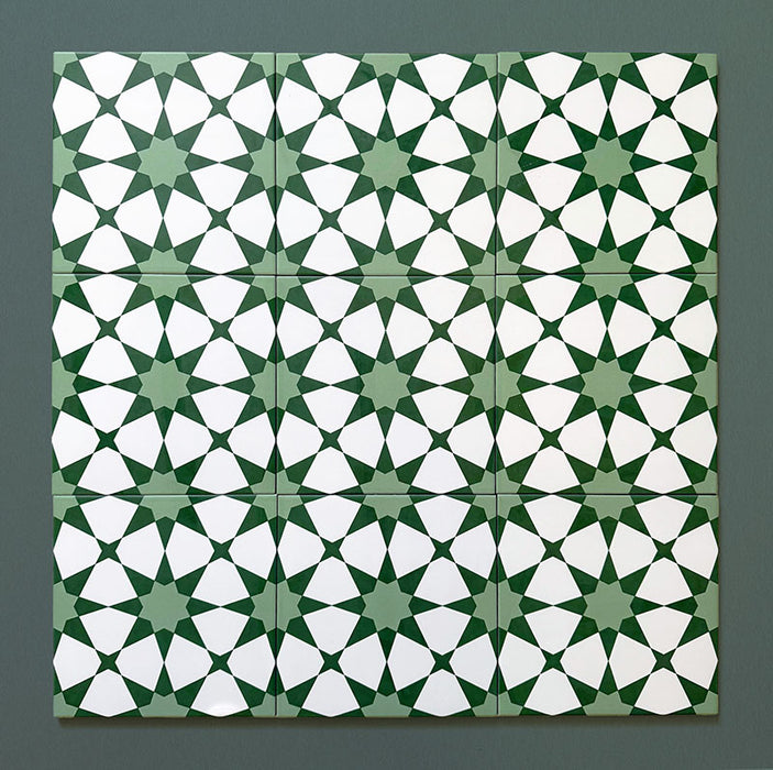 Group of Agraba Green 20x20cm Moroccan-style ceramic tiles showing a repeated geometric star pattern in rich green and white tones, displayed on a dark green background to highlight the intricate design.