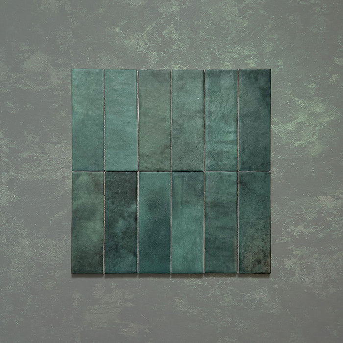 Zellij Gloss Green brick Moroccan style tiles, 6.5cm x 20cm, deep emerald and forest green tones with natural shade variation, glossy glazed finish, handmade look, grouped tile layout showcasing colour movement and texture.