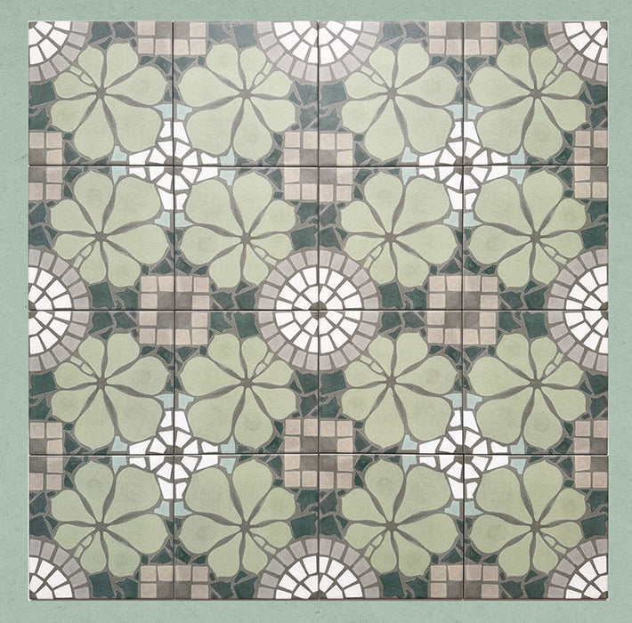 Group of Bloom Green 20x20cm Moroccan-style ceramic tiles arranged together, showcasing a repeating floral pattern in soft green, grey, and white tones on a green background.