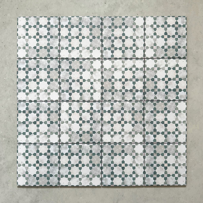 Bedouin Mequinez Green Moroccan-style 15x15cm tiles shown as a grouped layout, featuring a repeating geometric star and cross pattern in green, white, and grey with a handcrafted, rustic finish.