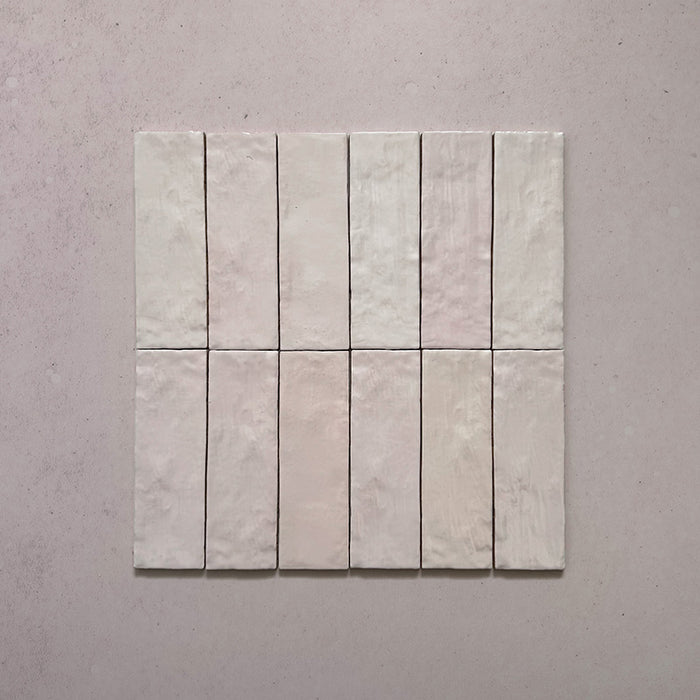 Zellij Pink Mist brick tile collection, 6.5cm x 20cm, rectangular Moroccan-style tiles arranged in a group, soft blush pink tones with subtle colour variation, glossy glazed finish, handcrafted look.