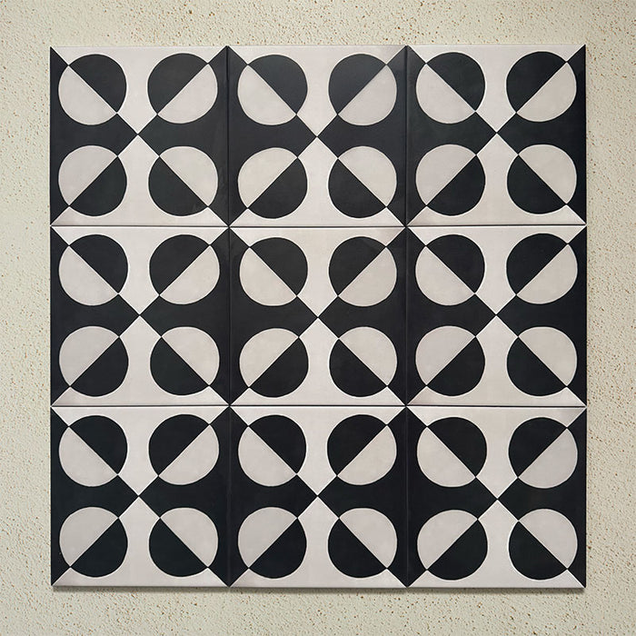 Group image showing multiple Geometry Illusion Noir 20x20cm geometric patterned tiles arranged in a repeating layout, featuring bold black and cream semicircles forming a striking symmetrical pattern, photographed against a textured neutral background.