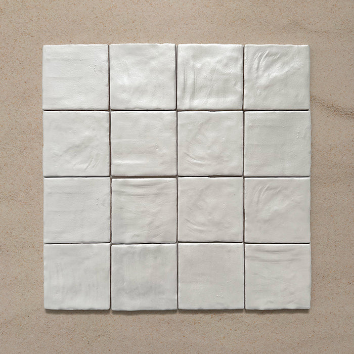 Zellij Oyster Square Moroccan-style tiles in a 10cm x 10cm format, arranged as a grouped layout to highlight the glossy off-white glaze and natural handmade surface variation on a neutral background.