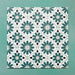 Flatlay featuring a group of Clarence House Teal Green 20x20cm Victorian Moroccan-style porcelain tiles, displaying a repeating geometric floral pattern in teal, white, and black on a green background.