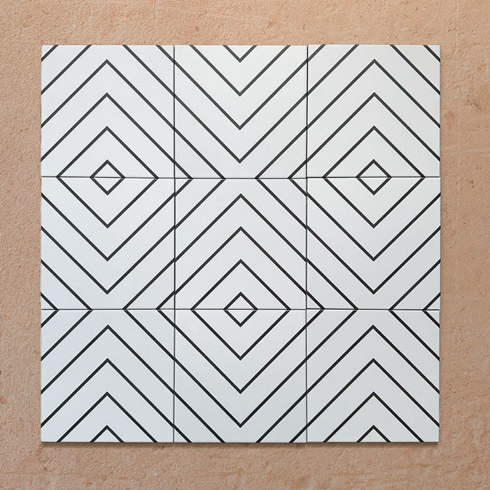 Alhambra Zig Zag Blanco 20x20cm Moroccan tiles shown in a grouped layout, featuring a bold black and white chevron pattern with diamond detailing for a contemporary geometric look.