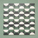 Group image showing multiple Geometry Circulo 20x20cm geometric patterned tiles arranged in a repeating layout, featuring green, black, and cream semicircle motifs, photographed against a soft green textured background.