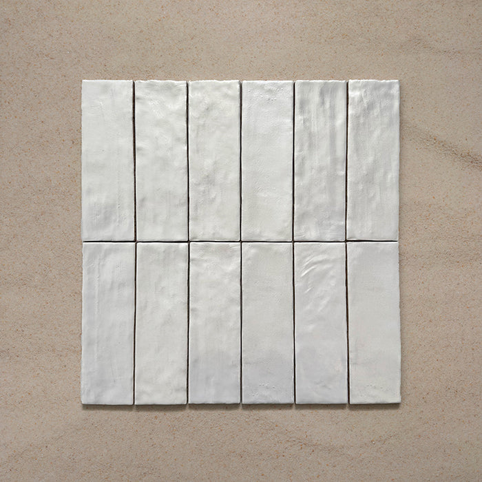 Zellij Oyster Brick Moroccan-style tiles in a 6.5cm x 20cm brick format, arranged as a grouped layout to showcase the glossy off-white glaze and natural surface variation on a neutral background.