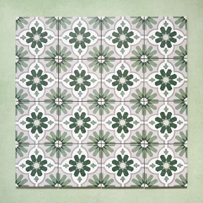 Flatlay featuring a group of Clarence House Jade Mini 15x15cm Victorian Moroccan-style porcelain tiles, displaying a repeating green and white geometric floral pattern on a soft green background.