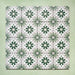Flatlay featuring a group of Clarence House Jade Mini 15x15cm Victorian Moroccan-style porcelain tiles, displaying a repeating green and white geometric floral pattern on a soft green background.