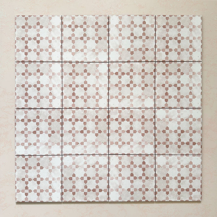 Bedouin Mequinez Rose Moroccan-style 15x15cm group of tiles showing the repeated geometric star and cross pattern in soft rose pink, beige, and white hues. The layout highlights the tile’s handcrafted appearance, matte finish, and uniform grout lines on a warm-toned background.