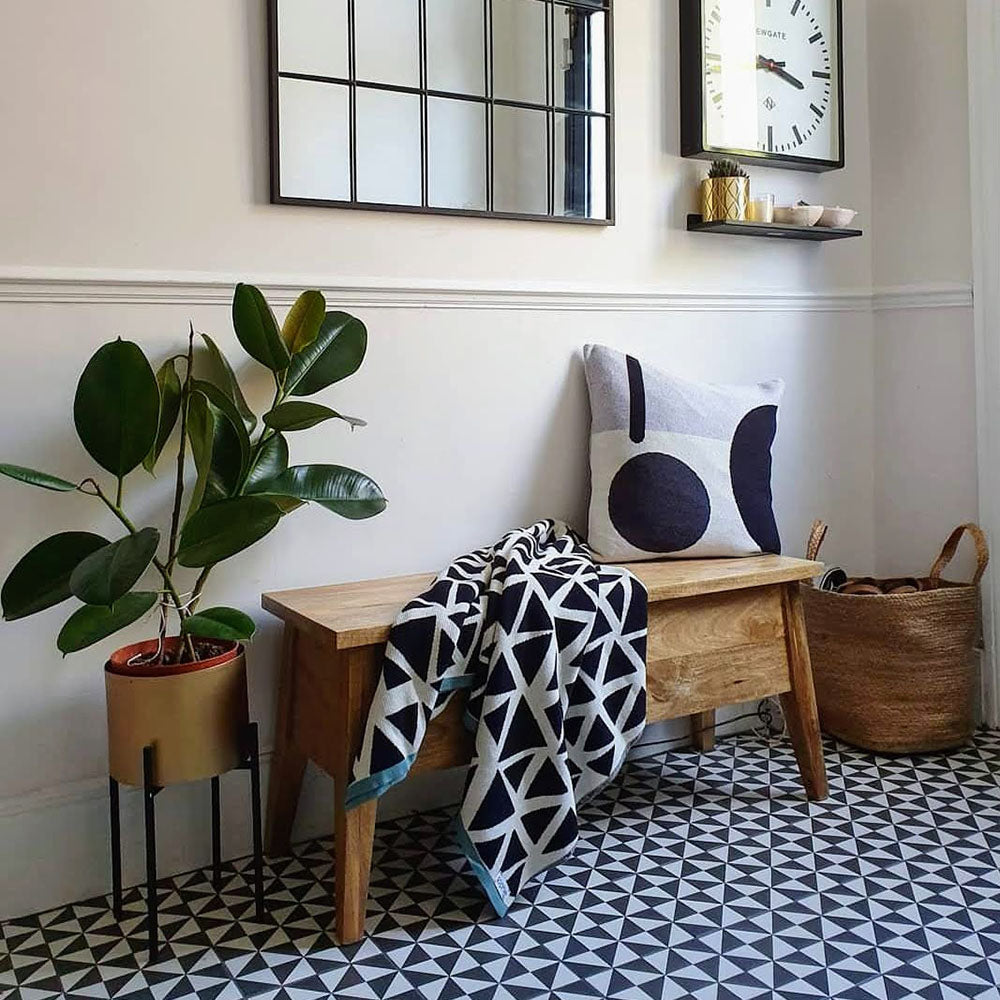 Hallway featuring Sloane Square Diamonds Black and White 25x25cm Victorian-style ceramic floor tiles, arranged in a geometric diamond pattern, styled with a wooden bench, patterned cushion, indoor plant, and decorative wall mirror.