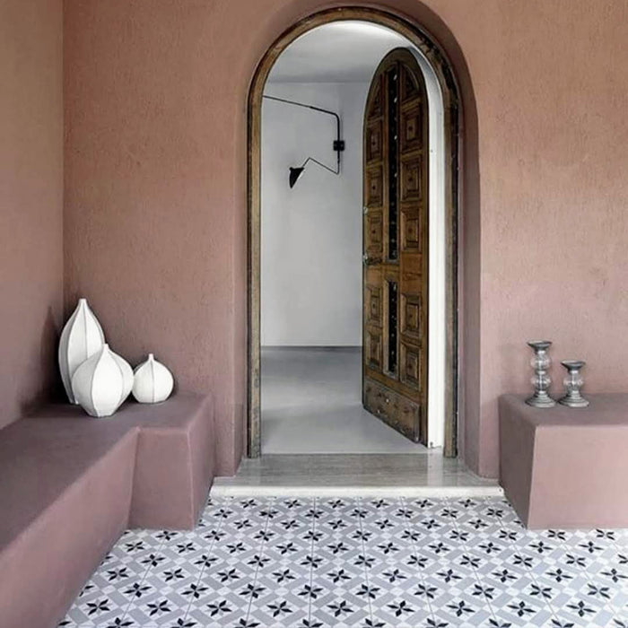 Hallway setting featuring Georgetown Star Victorian-style 20x20cm patterned porcelain floor tiles, creating a classic monochrome look beneath soft pink plaster walls and an arched doorway.