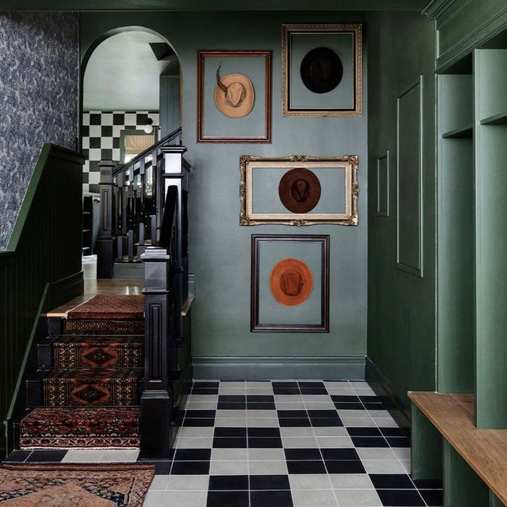 Hallway setting featuring Maison Plain Black Base 20x20cm Victorian style tiles paired with contrasting white tiles in a classic chequerboard layout, creating a bold geometric floor, styled with deep green walls and traditional details for a timeless, characterful finish.