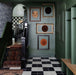 Hallway setting featuring Maison Plain Black Base 20x20cm Victorian style tiles paired with contrasting white tiles in a classic chequerboard layout, creating a bold geometric floor, styled with deep green walls and traditional details for a timeless, characterful finish.