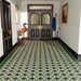 Victorian-style hallway featuring Maison Green Decor patterned 20x20cm ceramic floor tiles with black, white and green geometric design.