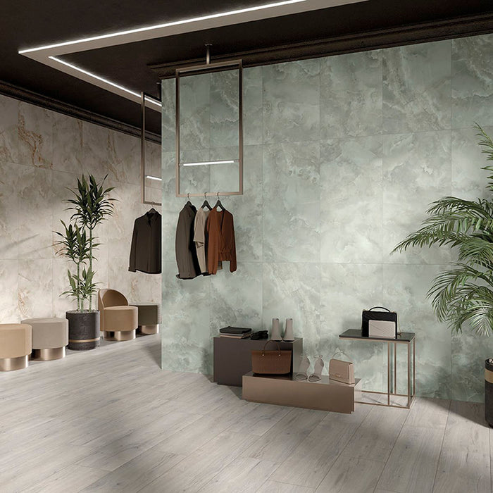 Contemporary commercial interior featuring Hashim Ivory Honed Matt Onyx porcelain tiles as a large-format feature wall. The soft ivory onyx-effect veining creates a refined focal point, complemented by pale wood effect flooring, indoor greenery and minimalist furnishings for a bright, luxurious space.