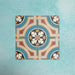 Four Europa Helsinki 20x20cm Victorian Moroccan style tiles arranged together to showcase the repeating geometric pattern in teal, terracotta, cream and black tones, displayed against a textured aqua background.