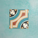 Single Europa Helsinki 20x20cm Victorian Moroccan style tile displayed against a textured aqua background, featuring a decorative geometric corner pattern in teal, terracotta, cream and black tones in a close-up product setting.