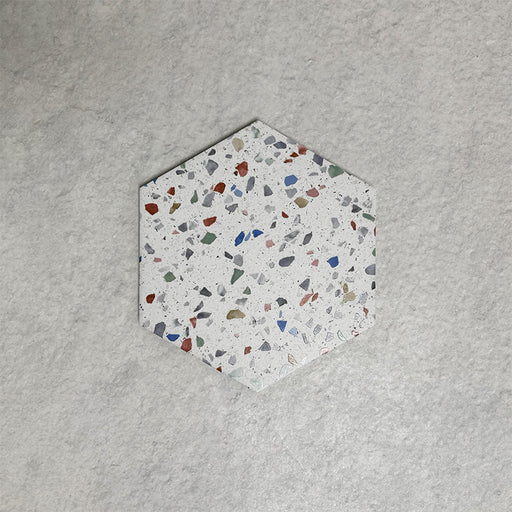 Single Confetti Tutti Frutti Hexagon 22×25cm terrazzo-style porcelain tile featuring colourful multitone chips on a white base, displayed against a light textured background.