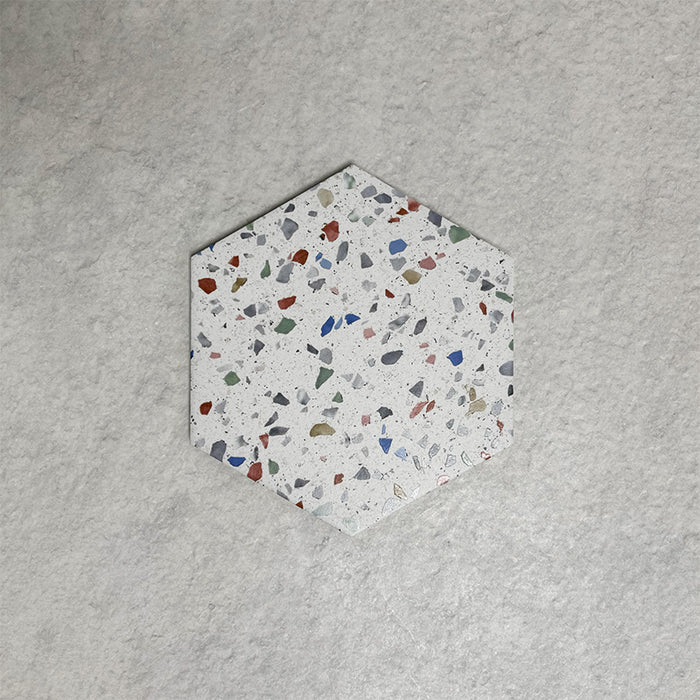 Single Confetti Tutti Frutti Hexagon 22×25cm terrazzo-style porcelain tile featuring colourful multitone chips on a white base, displayed against a light textured background.