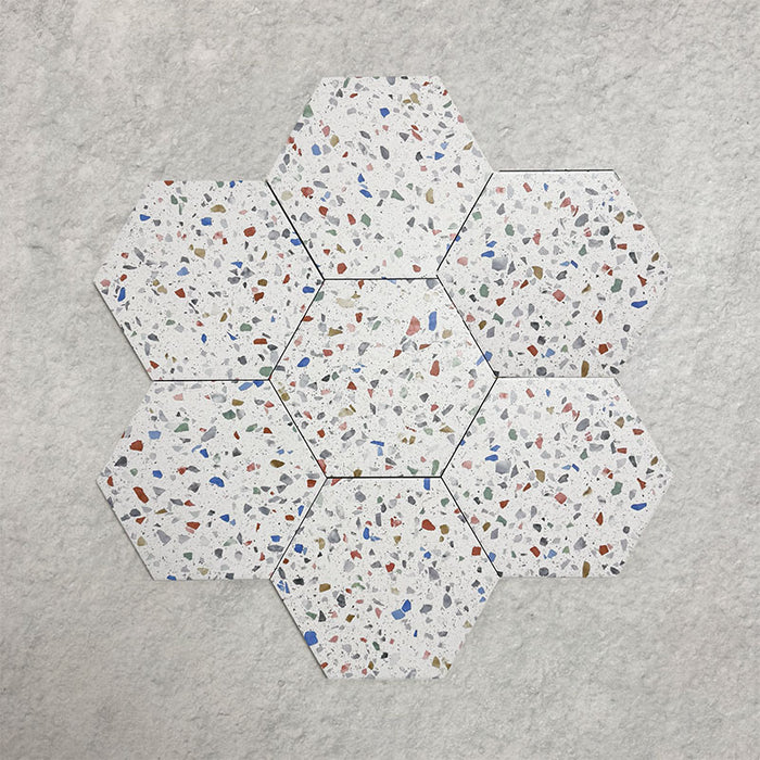 Group of seven Confetti Tutti Frutti Hexagon 22×25cm terrazzo-style porcelain tiles arranged in a honeycomb layout to show colour variation, multicoloured chips, and overall pattern effect on a white base, displayed against a light textured background.