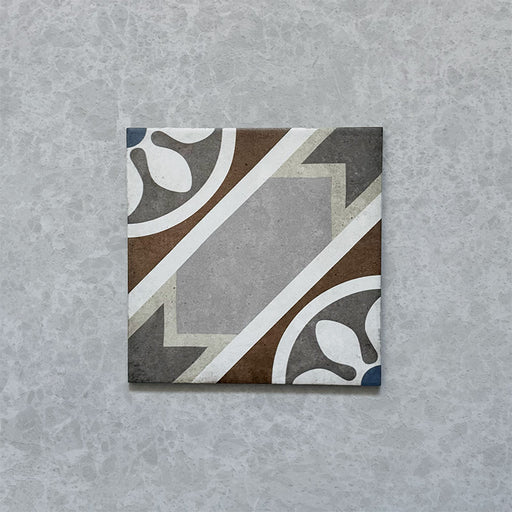 Single tile from the Carnaby Heythrop Victorian-style collection, 20x20cm porcelain wall and floor tile, featuring a geometric floral pattern in taupe, terracotta, grey, and blue on a softly aged background.