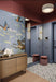 Hallway interior featuring Belgravia Black & White 28x28cm Victorian-style patterned floor tiles, styled with blue panelled walls, statement wallpaper, warm wood console, and soft lighting in a contemporary entrance space.