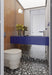 Bathroom setting featuring Noventa Terrazzo Nero 59x59cm matt porcelain wall and floor tiles, showcasing a bold terrazzo effect with crisp white stone fragments set against a deep black base, carried across both floor and stepped detailing, paired with warm wood panelling and a striking cobalt vanity for a contemporary, design-led finish.
