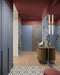 Hallway interior featuring Belgravia Black & White 28x28cm Victorian-style patterned floor tiles, styled with blue panelled walls, statement wallpaper, warm wood console, and soft lighting in a contemporary entrance space.