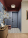 Hallway interior featuring Belgravia Black & White 28x28cm Victorian-style patterned floor tiles, styled with blue panelled walls, statement wallpaper, warm wood console, and soft lighting in a contemporary entrance space.